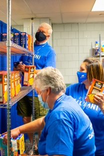 Alumni volunteers stock the campus food pantry. 