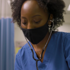 Joan Tufuor, a UB Nursing student, checks a patient's heartbeat. 