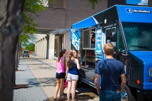 Students standing in front of the Little Blue food truck. 