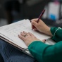 Image of person writing in a notebook. 