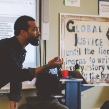 Blake Thompson teaching in a classroom in a black shirt. 