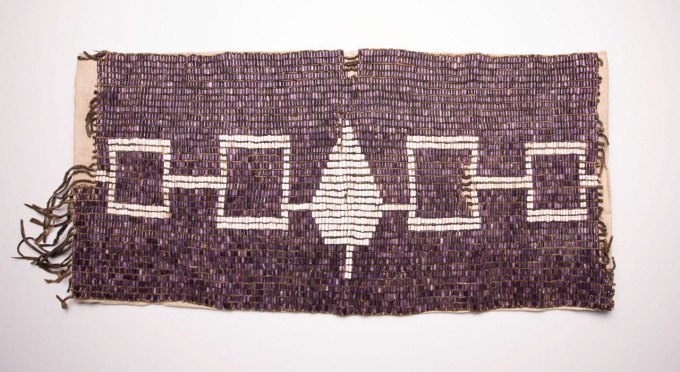purple belt made of wampum beads that shows the flag image of the Haudenosaunee people. 