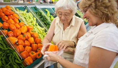 Photo of older adult with younger woman shopping together. 