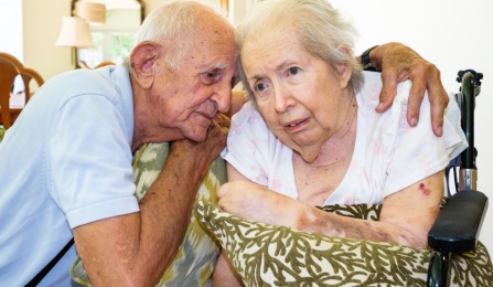 Photo of older gentlemen with arms around older woman. 