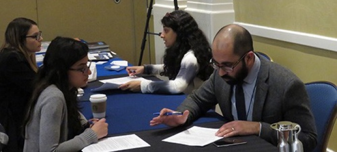 Mentors and mentees discuss job market documents at the annual NeMLA convention. 