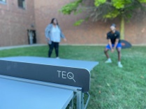 Teqball table with two students blurred in the background. 