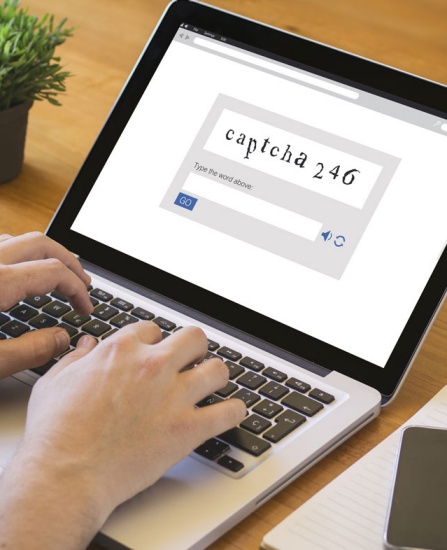 Man filling out CAPTCHA on laptop. 