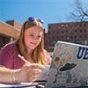 Student studying at her laptop outside on a sunny day. 