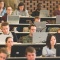 Students on laptops in a lecture hall. 