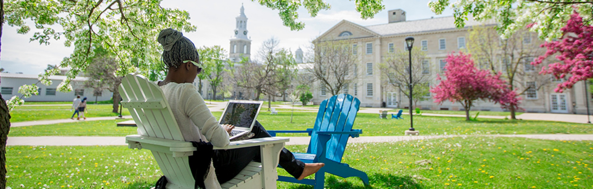  A student working on a laptoo outside on a sunny day on South Campus. 