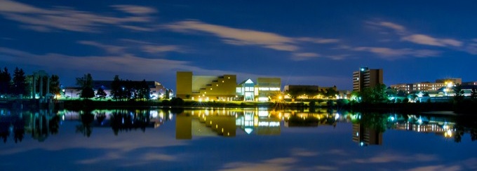 u b center for the arts at night from across lake lasalle. 