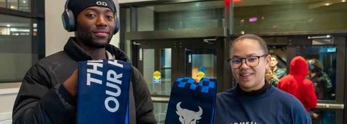 Male UB student and female professional staff member posed with custom UB scarf. 