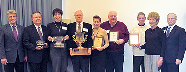 Vice President David Dunn (far left) and President John B. Simpson (far right) flank representatives accepting awards at the Jan. 26 celebration. They are, from second on the left, James Nadbrzuch, Student Affairs; Connie Holoman, External Affairs; Mick Thompson, Office of the Provost; Sally Sams, Nursing; John Shellum, Management; and Jack and Lee Baker, Emeritus Center. Photo: JIM BISCO
