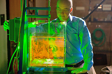 Sean Bennett studies fluorescent tracer particles in a mixing box illuminated by the laser light sheet used in PIV. These images allow him to quantify the speed and direction with which particles move through the fluid.