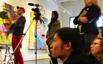 Students filming a speaker in an art gallery on the Rust Belt Tour. 