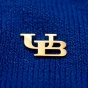 UB gold lapel pin on blue background. 