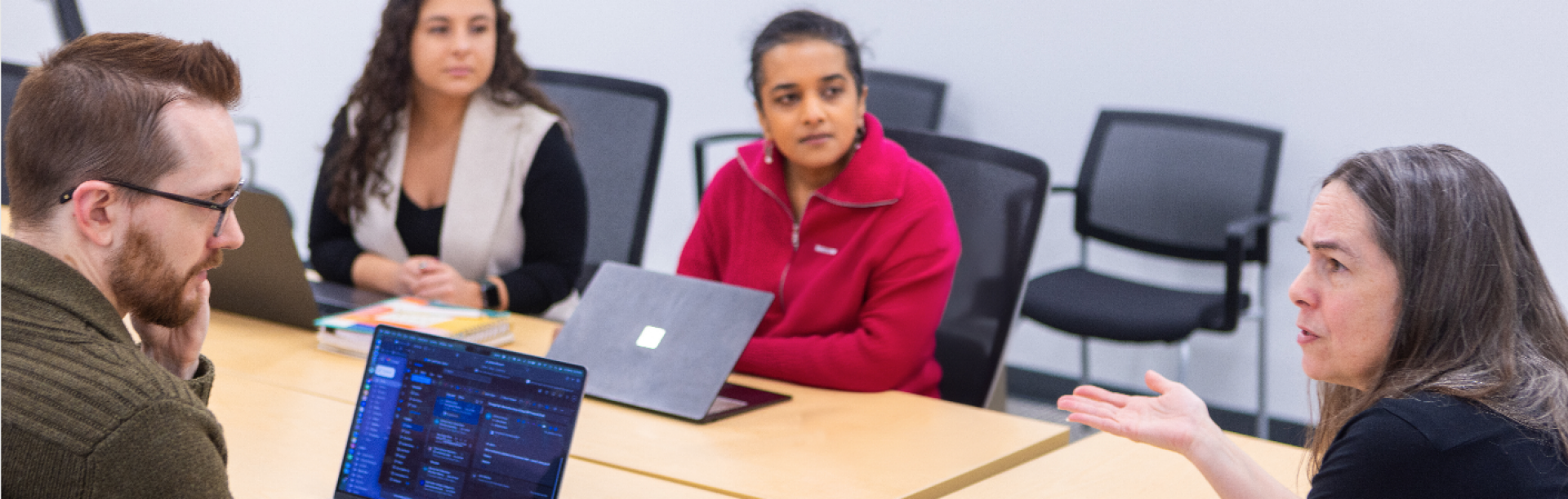 Melanie Green is discussing with her graduate students in a conference room.