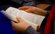 Image of student reading a book on poetics. 