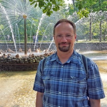 Portrait of Professor Adam Sikora who is helping advance and popularize the growing field of quantum topology, which connects topology and geometry with quantum physics through surprising cross-fertilization of ideas. He co-organized three international conferences and a summer school devoted to this area. The first three NSF-supported events were held at Vietnam Institute for Advanced Study in Mathematics and at the Centre International de Rencontres Mathématiques (CIRM) in Marseille, France, in summer 2025. Another meeting, exploring connections with Number Theory, will take place at the Mathematisches Forschungsinstitut Oberwolfach in Germany. 