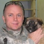 Portrait of William Mandrick, PhD, on a deployment, with a puppy found after a firefight with al Qaeda insurgents. Puppy was adopted by US forces. Mandrick observes, "We liked having dogs around because they sense when something is not right.". 