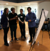 Conner Awayda, right, discusses his poster with competition participants.