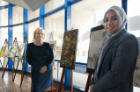 Ginny O’Brien, curator of education for UB Art Galleries (left), and first-year medical student Nabiha Ahsan stand by their artwork.