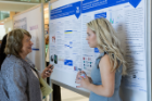Margarita L. Dubocovich, PhD, SUNY Distinguished Professor of pharmacology and toxicology, left, listens to Hannah Zimmerman explain her research in the CLIMB Undergraduate Biomedical Informatics and Data Science program.