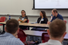 Microbiology and immunology doctoral student Mary Gallo, left, speaks during a breakout session as biochemistry doctoral student Alex Sunshine and Aimee Morris of the University of Rochester look on.