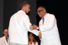 Mark Lauria receives congratulations from David A. Milling, MD, senior associate dean for student and academic affairs.