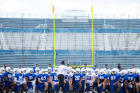 WEDNESDAY, AUG. 10, 12:27 P.M. TEAM TALK Players take a knee while UB Bulls head football coach Maurice Linguist (Coach Mo), provides inspiration for the team and assistant coaches during a summer practice in UB Stadium. PHOTO BY MEREDITH FORREST KULWICKI