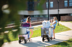 Students and families move carts packed with their belongings into Governors Residence Halls on the North Campus. After a year-and-a-half of mostly remote instruction, UB implemented health and safety protocols to ensure a safe and successful 2021-22 academic year. PHOTO BY DOUGLAS LEVERE