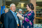Ron Leta, BS ’72, getting his boutonniere pinned on by UB staff member Brittany Valvo.