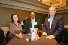 Featured presenters Mara Huber and Praveen Arany smile with Eric Alcott. 