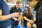 Ariana Allman (center with curly hair), a senior majoring in biomedical engineering, prepares to place a large marshmallow at the top of the tower.
