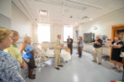 Attendees learning about a room during a tour of the Jacobs School of Medicine and Biomedical Sciences building. 