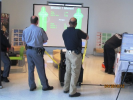 Two law enforcement officers demonstrate a virtual target practice presentation at the 2011 Albany Caucus 