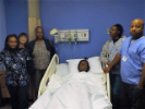 Nursing students pose around a hospital bed with a training mannequin