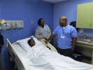 Man and woman chat by hospital bed with training mannequin