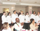 Newly-pinned dental assisting students pose for a group photo to applause from the audience