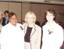 Two newly-pinned dental assisting students and a faculty member pose for a group photo
