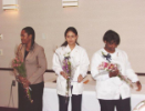 Three attendees hold bouquets