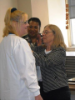 Two faculty members present a pin to a dental assisting student 
