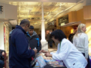 Dental Assisting school outreach volunteers hand out dental hygiene kits at a mall