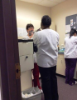 Dental assisting school student and faculty member check X-rays as another student works at lab counter