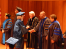 Graduate is congratulated by faculty members