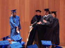 Graduate receives their award from faculty