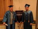 Two graduates next to EOC banners