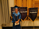Graduate next to EOC banners