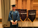 Graduate next to EOC banners