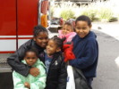 group of kids sitting on a fire truck